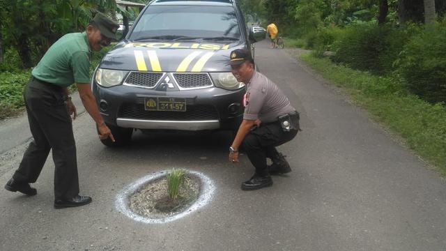 Polisi dan anggota TNI di Kebumen menandai jalan rusak dengan cat dan menanami padi di jalan berlubang. (Foto: Liputan6.com/Humas Pemkab Banyumas/Muhamad Ridlo)