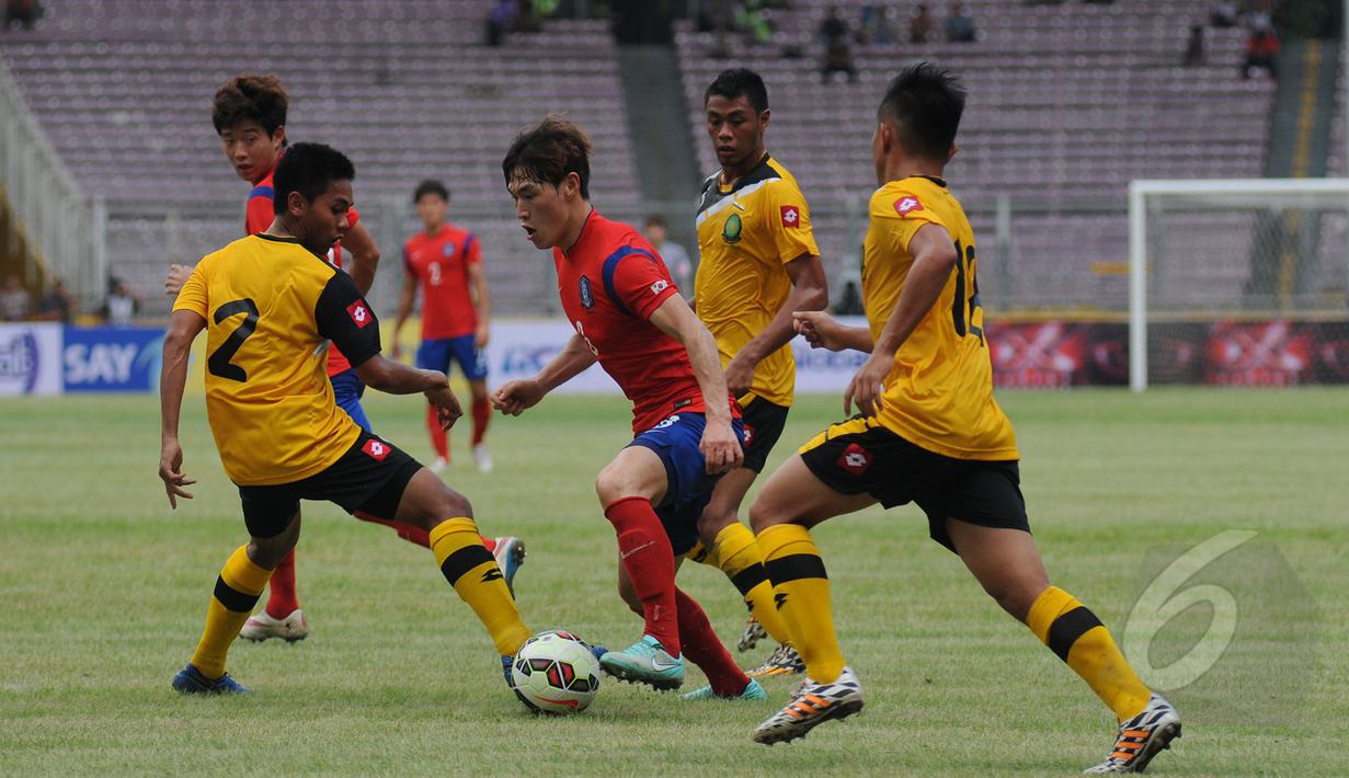 Gelandang Korea Selatan U-23, Lee Changmin (tengah) mencoba lolos dari kawalan tiga pemain Brunei Darussalam saat laga kualifikasi grup H Piala Asia 2016 di Stadion GBK, Jakarta, Jumat (27/3/2015). (Liputan6.com/Helmi Fithriansyah)