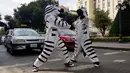 Aksi warga berpakaian seperti zebra saat menyapa pengendara saat program pendidikan di jalan di La Paz, Bolivia,(5/12). (REUTERS/David Mercado)