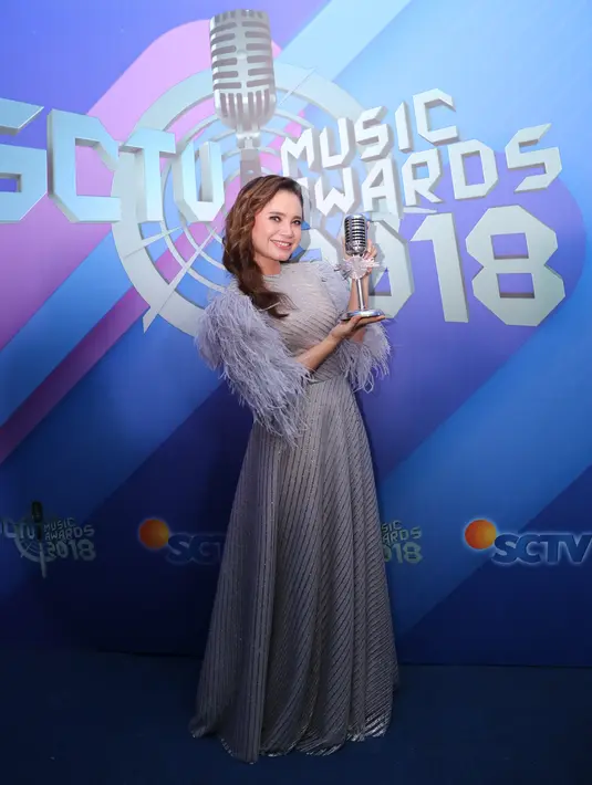 Pelantun lagu Takdir Cinta ini begitu cantik saat hadir di SCTV Music Awards kemarin. Ia mengenakan long dress berwarna abu-abu dan memiliki aksen bulu-bulu di bagian tangannya. (Adrian Putra/Bintang.com)