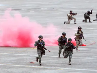 Tentara pasukan khusus Taiwan berlari melewati asap selama latihan tahunan Han Kuang di sebuah pangkalan udara di Taichung, Kamis (7/6). Latihan militer tahunan terbesar ini digelar di tengah kian agresifnya China terhadap Taiwan. (AP/Chiang Ying-ying)