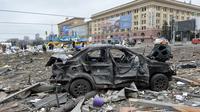 Sebuah mobil rusak di luar balai kota Kharkiv yang hancur akibat penembakan pasukan Rusia pada 1 Maret 2022. Alun-alun pusat kota terbesar kedua Ukraina, Kharkiv, dibombardir oleh pasukan Rusia -- menghantam gedung pemerintahan lokal -- kata gubernur Oleg Sinegubov. (Sergey BOBOK / AFP)