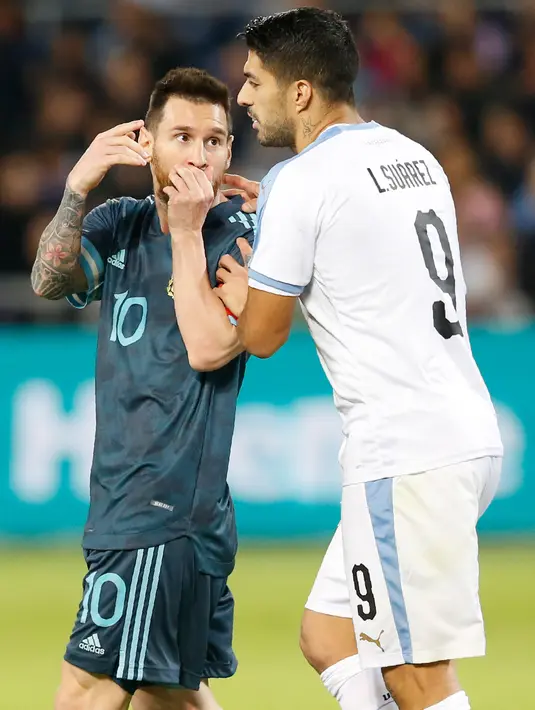 Megabintang timnas Argentina, Lionel Messi berbicara dengan pemain timnas Uruguay, Luis Suarez pada laga persahabatan di Stadion Bloomfield, Tel Aviv, Senin (18/11/2019). Messi dan Cavani bersitegang sehingga keduanya harus sampai dipisahkan rekan-rekannya. (AP/Ariel Schalit)