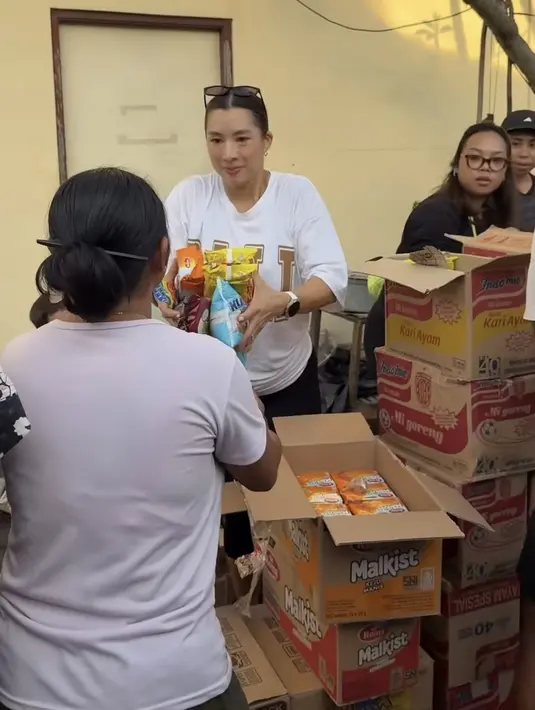 <p>Dengan senyum di wajahnya yang tak pernah berhenti, Jennifer membagikan bahan pokok kepada korban banjir. Tampak ia pun mengenakan t shirt oversize warna putih dengan tulisan Bali besar. [@jenniferbachdim]</p>