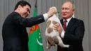 Presiden Rusia, Vladimir Putin (kanan) menerima anjing gembala Turkmen atau dikenal sebagai Alabai dari Presiden Turkmenistan Gurbanguly Berdimuhamedov saat pertemuan di Sochi, Rusia (11/10). (AFP Photo/Pool/Maxim Shemetov)