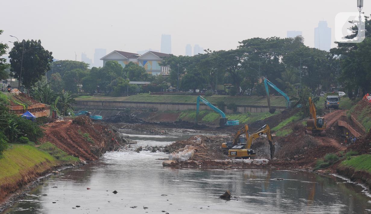 Alat berat excavator mengeruk tanah dan lumpur pada proyek pengendalian banjir sodetan Ciliwung di  Sungai Kanal Banjir Timur, Cipinang, Jakarta, Jumat (26/5/2023). (merdeka.com/imam buhori)