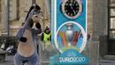Seorang penampil berkostum kuda berjalan dekat layar hitung mundur Piala Eropa 2020 di St. Petersburg, Rusia, Selasa (17/3/2020). UEFA resmi menunda Piala Eropa 2020 hingga tahun depan. (AP Photo/Dmitri Lovetsky)