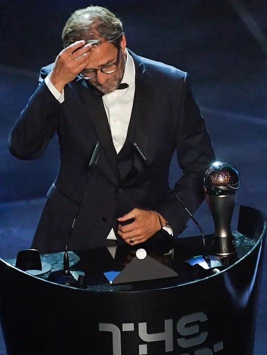 Pelatih Liverpool, Jurgen Klopp merapikan rambutanya saat memberi sambutan setelah meraih Pelatih Terbaik Dunia 2019 versi FIFA saat memberi sambutan di teater La Scala Milan, Italia utara (23/9/2019). (AFP Photo/Marco Bertorello)
