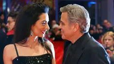 Aktor AS George Clooney dan istrinya, Amal Alamuddin berpose untuk fotografer saat tiba di karpet merah pemutaran film "Hail, Caesar!" pada pembukaan Berlin International Film Festival ke-66 di Berlin, Jerman, Kamis (11/2). (REUTERS/Fabrizio Bensch)
