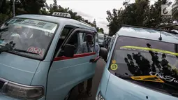 Para pengemudi angkutan memarkirkan mobilnya saat menggelar unjuk rasa di depan Balai Kota, Jakarta, Senin (22/1). Mereka meminta untuk membuka kembali Jalan Jatibaru Raya dan putaran di depan Blok A Tanah Abang. (Liputan6.com/Faizal Fanani)