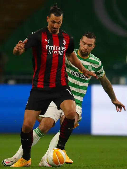 Pemain AC Milan Zlatan Ibrahimovic (kiri) mengontrol bola di depan pemain Celtic Shane Duffy (kanan) pada pertandingan leg pertama Grup H Liga Europa di Celtic Park, Glasgow, Skotlandia, Kamis (22/10/2020). AC Milan menang 3-1. (Jane Barlow/Pool via AP)