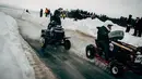 Pembalap tim Inggris, Gash it dan Bash It menyalip lawan mereka, tim Saoonjat Sipoon dari Finlandia selama berkompetisi dalam kejuaran balap mesin potong rumput tahunan di Lavia, Finlandia, 9 Februari 2019. (Alessandro RAMPAZZO/AFP)