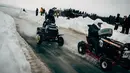 Pembalap tim Inggris, Gash it dan Bash It menyalip lawan mereka, tim Saoonjat Sipoon dari Finlandia selama berkompetisi dalam kejuaran balap mesin potong rumput tahunan di Lavia, Finlandia, 9 Februari 2019. (Alessandro RAMPAZZO/AFP)