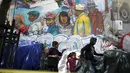 Orang berjalan melewati mural di Skid Row, Los Angeles, California, Kamis (1/10/2015). Kota Los Angeles menetapkan status darurat terkait makin rumitnya persoalan kaum tunawisma di sana. (REUTERS/Lucy Nicholson)