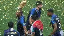 Pemain timnas Prancis, Djibril Sidibe memegang trofi Piala Dunia 2018 saat merayakan gelar juara setelah mengalahkan Kroasia pada  laga final di Luzhniki Stadium, Minggu (15/7). Prancis membekuk Kroasia dengan skor akhir 4-2. (AP Photo/Frank Augstein)