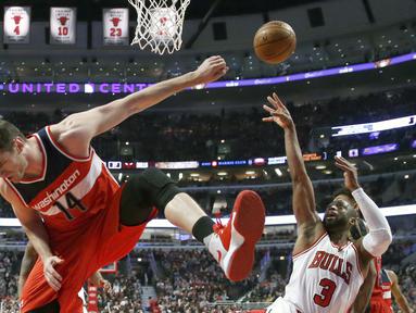 Pemain Chicago Bulls, Dwyane Wade (kanan) melakukan tembakan saat dihadang pemain Washington Wizards, Jason Smith pada laga NBA basketball game di United Center, Chicago, (21/12/2016).  Wizards menang 107-97. (AP/Charles Rex Arbogast)