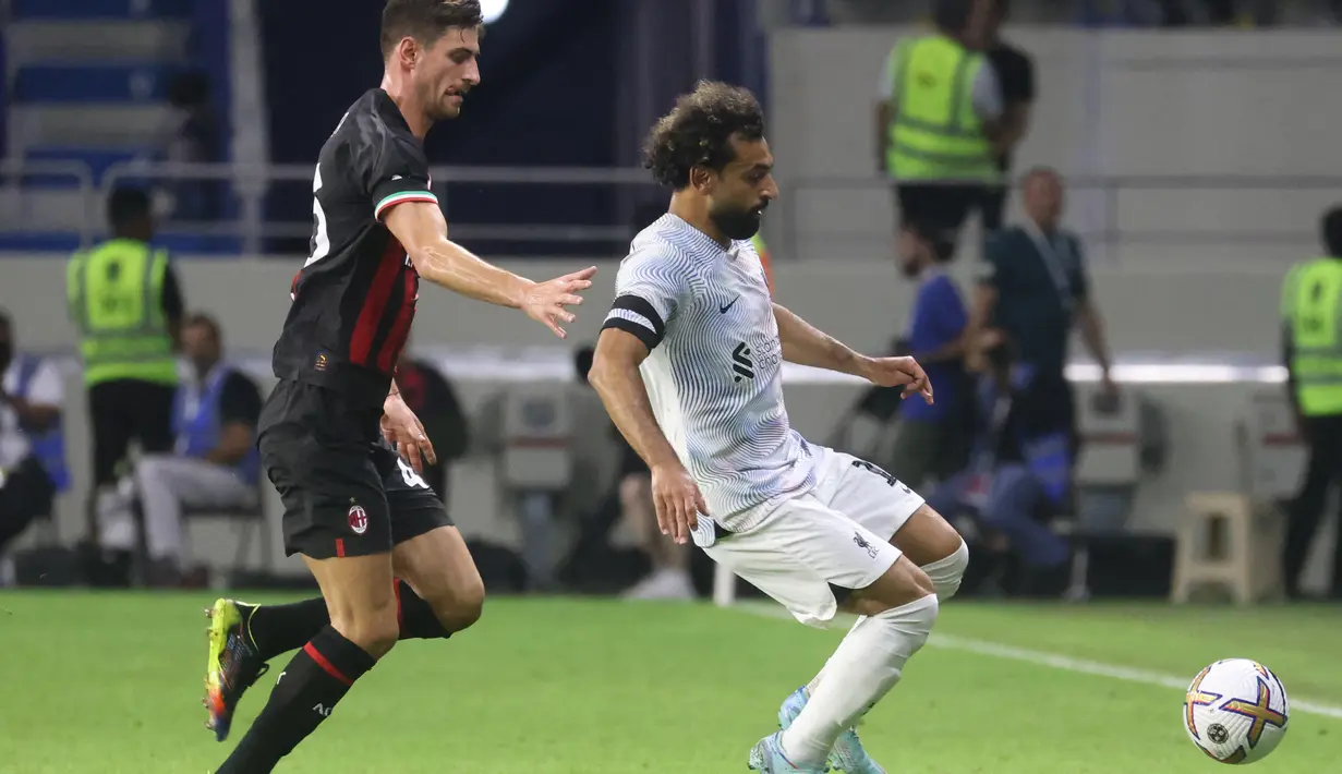 <p>Bek AC Milan, Matteo Gabbia (kiri) berusaha merebut bola dari penyerang Liverpool, Mohamed Salah selama pertandingan Dubai Super Cup 2022 di stadion al-Maktoum, Uni Emirat Arab, Jumat (16/12/2022). Liverpool menang telak atas AC Milan 4-1. (AFP/Karim Sahib)</p>