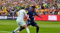Malo Gusto dan Vinicius Junior berebut bola dalam laga uji coba internasional antara Brasil vs Prancis di Gillette Stadium, Massachusetts, 27 Maret 2026. (AP Photo/Charles Krupa)