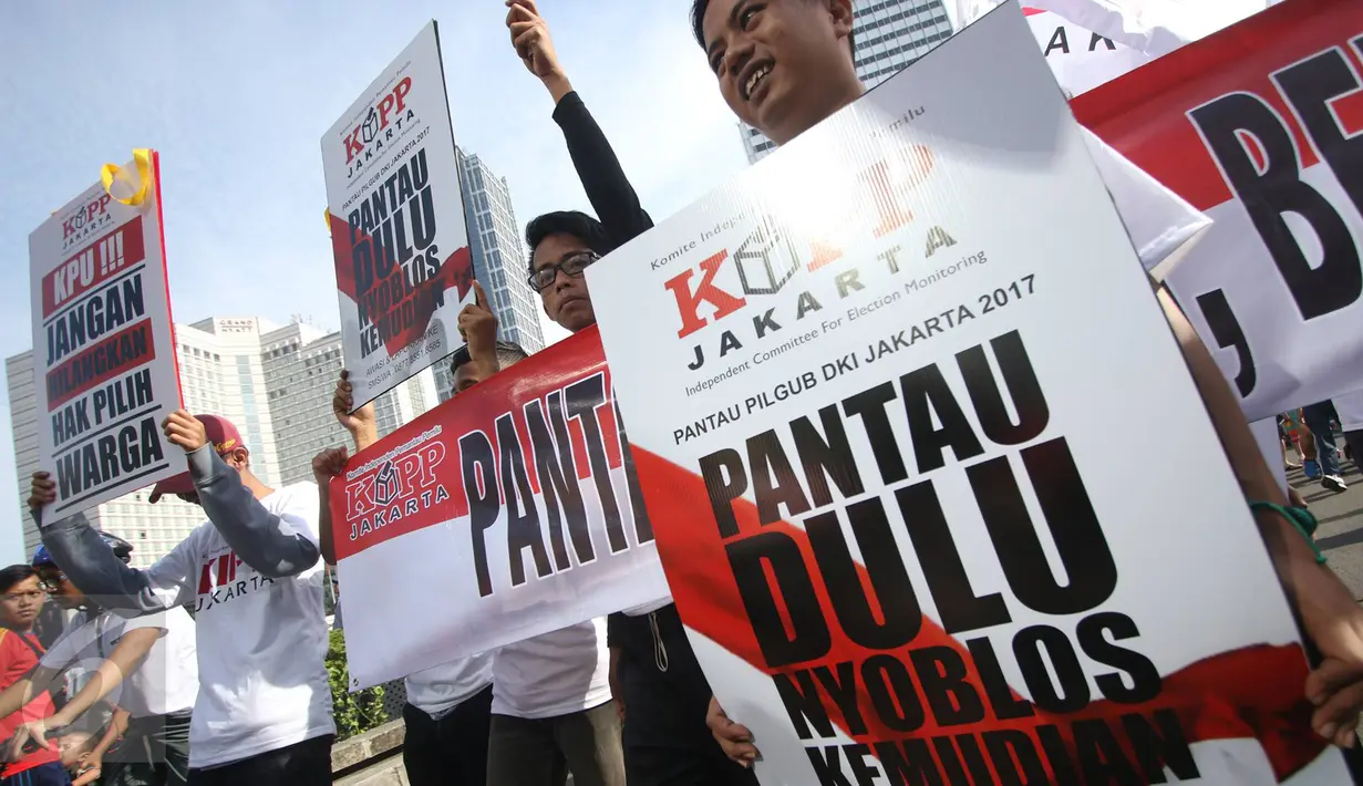 Massa Komite Independen Pemantau Pemilu (KIPP) membawa poster saat melakukan aksi damai terkait Pilkada DKI Jakarta, Minggu (12/3). (Liputan6.com/Immanuel Antonius)