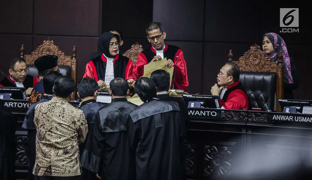 Majelis Hakim mengecek amplop yang dibawa Komisioner KPU, Hasyim Asyari disaksikan tim kuasa hukum pasangan Prabowo-Sandiaga selama sidang lanjutan sengketa pilpres 2019 di Gedung MK, Jakarta, Kamis (20/6/2019). Selain itu juga tidak ada bekas lem pada amplop itu. (Liputan6.com/Faizal Fanani)