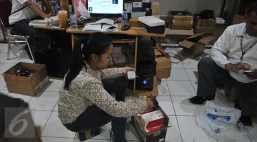Petugas Bareskrim Polri melakukan penggeledahan dan penyitaan terhadap sejumlah telepon seluler ilegal di gudang distributor, di ruko kawasan Cempaka Mas, Jakarta, Senin(15/6/2015). (Liputan6.com/Herman Zakharia)
