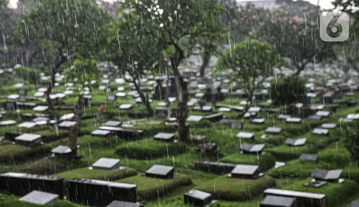 Hujan turun di Tempat Pemakaman Umum (TPU) Karet Bivak, Jakarta, Minggu (27/6/2021). Pemerintah Provinsi DKI Jakarta membatasi aktivitas dan kunjungan ke TPU hingga 5 Juli 2021 untuk menekan penularan COVID-19. (Liputan6.com/Faizal Fanani)