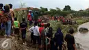 Proses penyisiran bangkai mobil yang diduga terdapat jenazah korban musibah banjir bandang di Cimacan menjadi tontonan warga, Garut (23/9). Data terakhir, korban jiwa mencapai 26 orang dan warga yang hilang 23 orang. (Liputan6.com/Johan Tallo)