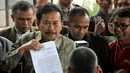 Bupati Tapanuli Tengah Raja Bonaran Situmeang memperlihatkan dokumen harta kekayaannya terhadap awak media sebelum menjalani pemeriksaan oleh KPK, Jakarta, Senin (6/10/2014) (Liputan6.com/Miftahul Hayat)