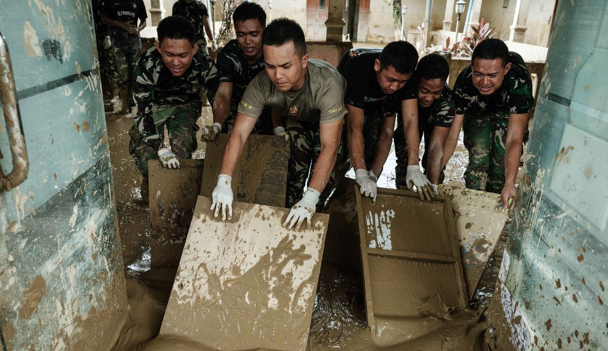 Rumah Sakit Daerah Aceh Tamiang mulai kembali beroperasi secara bertahap setelah sempat lumpuh total akibat banjir bandang pada akhir November 2025 lalu. Tampak dalam foto, personel Tentara Nasional Indonesia (TNI) dari YONIF TP 853/BRB, Aceh Timur, membersihkan lumpur di Rumah Sakit Daerah di Aceh Tamiang, pada Selasa 16 Desember 2025, setelah banjir bandang sekitar tiga minggu lalu. (Yasuyoshi Chiba/AFP)