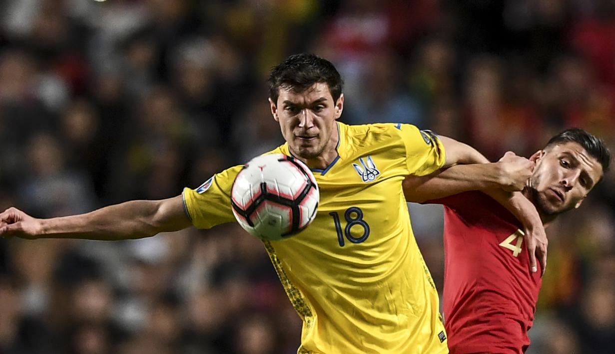 Striker Ukraina, Roman Yaremchuk, berusaha melewati bek Portugal, Ruben Dias, pada laga Kualifikasi Piala Eropa 2020 di Stadion Luz, Lisbon, Jumat (22/3). Kedua negara bermain imbang 0-0. (AFP/Patricia De Melo Moreira)