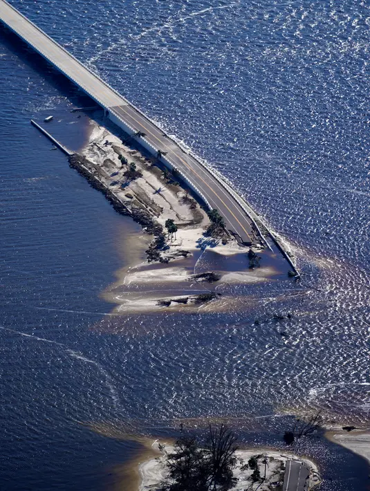 Foto udara dalam penerbangan yang disediakan oleh mediccorps.org, kerusakan akibat Badai Ian terlihat di jalan lintas menuju Pulau Sanibel dari Fort Myers, Florida, Amerika Serikat, 30 September 2022. Regu penyelamat mengemudikan perahu dan mengarungi jalan-jalan yang tergenang air untuk menyelamatkan ribuan warga Florida yang terperangkap akibat rumah terendam banjir dan bangunan-bangunan hancur. (AP Photo/Gerald Herbert)