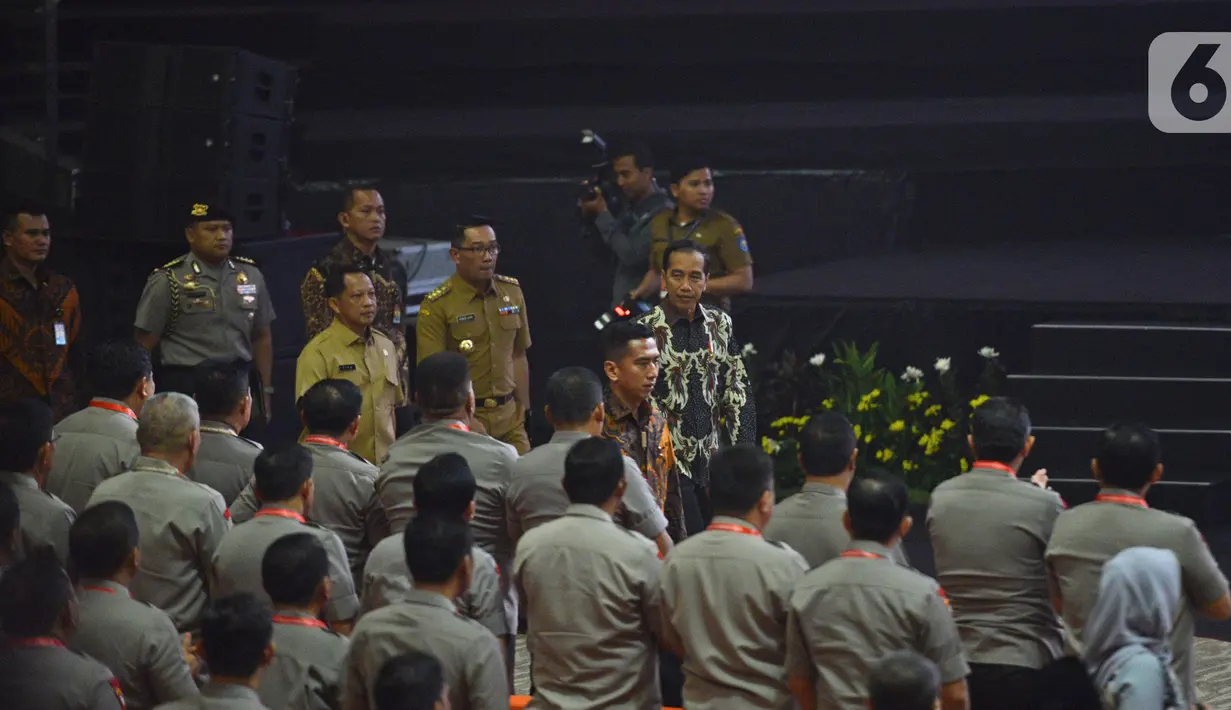 Presiden Joko Widodo (tengah) saat tiba pada Rakornas Indonesia Maju antara Pemerintah Pusat dan Forum Koordinasi Pimpinan Daerah (Forkopimda) di Bogor, Jawa Barat, Rabu (13/11/2019). Forum ini untuk mensinergikan program-program pemerintah pusat dengan daerah. (Liputan6.com/Herman Zakharia)