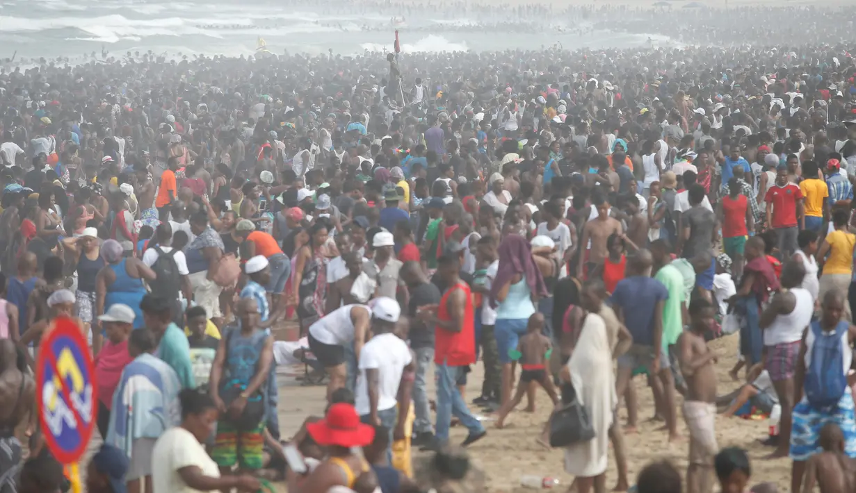 Pengunjung memadati pantai saat menikmati liburan awal Tahun Baru 2017 di sebuah pantai di Durban, Afrika Selatan (1/1). (REUTERS/Rogan Ward)