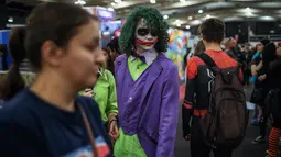 Seorang cosplayer berkostum ala karakter The Joker berjalan melalui kerumunan orang dalam acara Comic Con Africa di Johannesburg, Sabtu (21/9/2019). Comic Con Africa untuk tahun kedua di benua itu  akan berlangsung selama empat hari dari 21 hingga 24 September. (Michele Spatari/AFP)