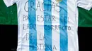 Jersey timnas Argentina yang bertuliskan ungkapan terima kasih dari aktivis pro-Palestina dipajang di Barcelona (6/6). Timnas Argentina membatalkan pertandingan persahabatan melawan Israel di Yerusalem. (AFP Photo/Pau Barrena)