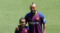 Pemain baru Barcelona, Arturo Vidal berpose dengan putranya Alonso Vidal selama presentasi dirinya di stadion Camp Nou, Spanyol, (6/8). Vidal dibeli Barcelona dari klub Jerman, Bayern Munchen. (AP Photo/Manu Fernandez)