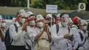 Massa calon pekerja migran Indonesia berunjuk rasa di kompleks Kemenaker, Jakarta, Senin (18/10/2021). Mereka membawa bendera Indonesia dan Korea Selatan, hingga poster bertuliskan "Buka kembali penempatan G to G Korea Selatan", "Kami butuh penempatan di Korea Selatan". (Liputan6.com/Faizal Fanani)