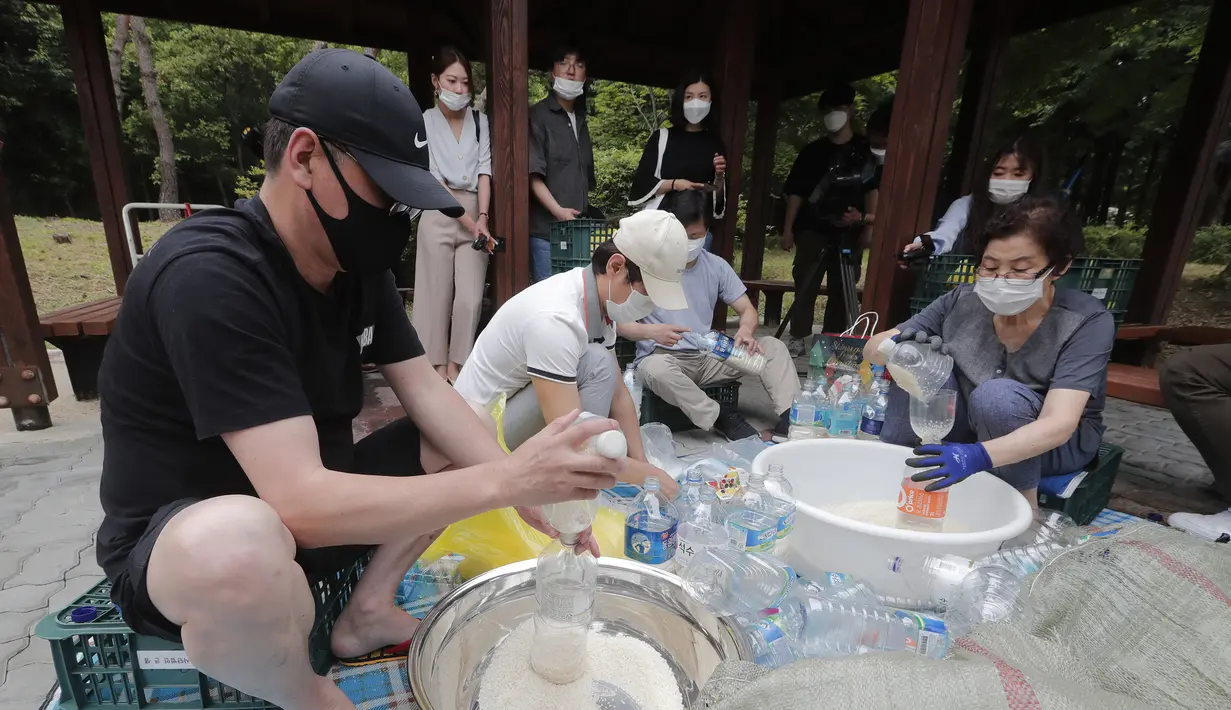 Para pembelot Korea Utara mengisi botol-botol plastik dengan beras dan masker untuk dikirim ke Korea Utara dengan balon, Seoul, Korea Selatan, Kamis (18/6/2020). Pembelot mengabaikan larangan resmi Korea Selatan untuk tidak mengirimkan benda apapun ke wilayah Korea Utara. (AP Photo/Ahn Young-joon)