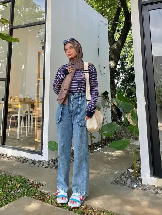 Stripe tee dengan high waist jeans jadi kombinasi outfit yang kece untuk kamu yang ingin liburan ke pantai. Tetap stylish! (Instagram/adiva.selsa).