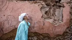 Seorang perempuan bereaksi berdiri di depan rumahnya yang rusak akibat gempa di kota tua di Marrakesh, Maroko pada 9 September 2023. (Photo by FADEL SENNA / AFP)