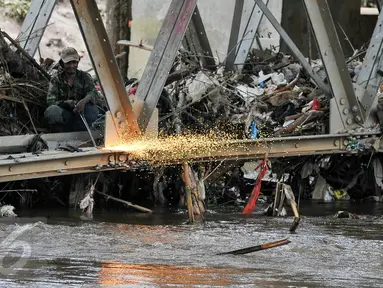 Petugas mengelas besi pondasi jembatan Rawajati untuk mempermudah pembongkaran, Jakarta, Selasa (15/3). Gubernur DKI Basuki Tjahaja Purnama meminta Dinas PU segera membongkar Jembatan tersebut karena menjadi penyebab banjir. (Liputan6.com/Yoppy Renato)