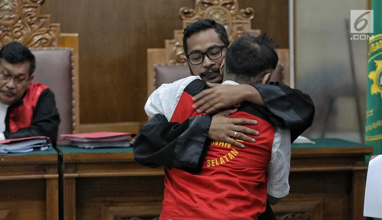 Terdakwa kasus penyalagunaan narkoba, Tio Pakusadewo memeluk kuasa hukumnya saat sidang lanjutan di PN Jakarta Selatan, Kamis (12/7). Sidang beragendakan pembacaan duplik atas replik dari JPU pekan lalu. (Liputan6.com/Faizal Fanani)
