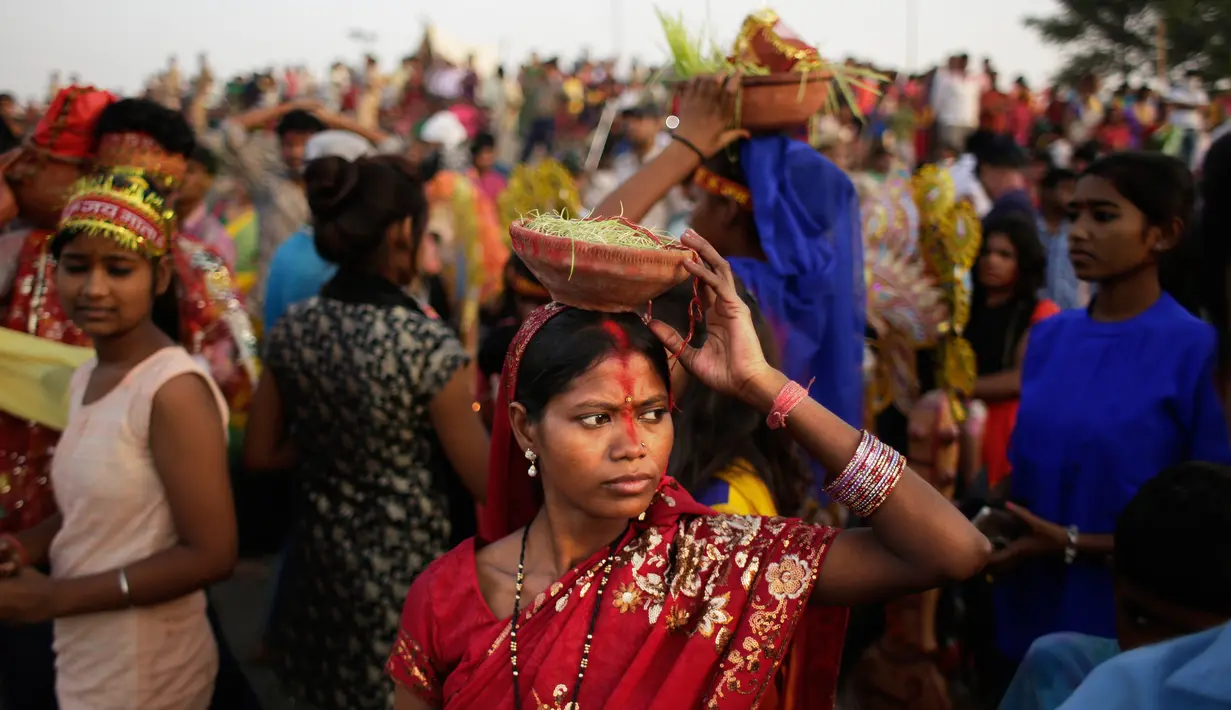 Perempuan Hindu India membawa pot tanah di kepalanya selama ritual Dewi Durga di sungai Yamuna di hari terakhir festival, New Delhi, India (11/10). Ditenggelamkannya patung ini menandai berakhirnya festival Durga Puja. (AP Photo/Altaf Qadri)
