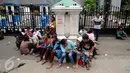 Warga Kalijodo terlihat duduk-duduk saat aksi di depan gedung DPRD DKI Jakarta, Jumat (19/2/2016). Dalam aksinya, mereka menuntut ganti rugi lahan pemukiman dan kepastian relokasi pemukiman. (Liputan6.com/Helmi Fithriansyah)