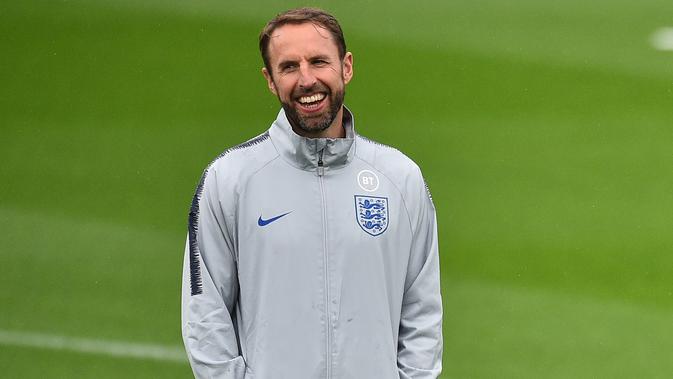 Pelatih Inggris, Gareth Southgate tersenyum saat melihat pemainnya berlatih di Staplewood Campus di southampton, Inggris selatan (9/9/2019). Inggris akan bertanding melawan Kosovo pada grup A Kualifikasi Euro 2020 di Stadion Saint Mary. (AFP Photo/Glyn Kirk)