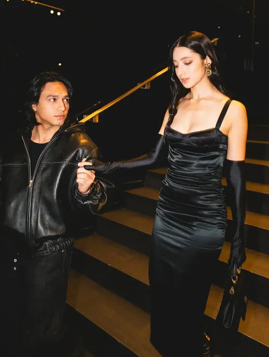 Gaun spaghetti strap ini dipadukan dengan opera gloves senada yang memberi aksen vintage namun tetap modern. Sepasang ankle boots pointed-toe dan tas tangan mini menambahkan kesan polished pada keseluruhan look-nya. Rambut yang ditata loose wave dan sentuhan makeup bold pada mata serta bibir membuat penampilannya kian memukau. [@jefrinichol].