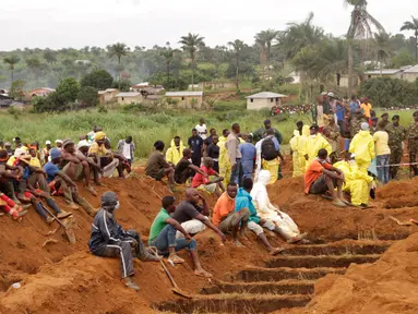 Relawan bersiap memakamkan massal korban banjir dan tanah longsor di sebuah pemakaman di Sierra Leone, Freetown, (17/8). Pemerintah setempat telah mengubur 350 orang yang tewas akibat musibah tersebut. (AP Photo/Kabba Kargbo)