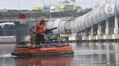 Petugas Unit Penanganan Sampah Badan Air Dinas Lingkungan Hidup (UPS Badan Air Dinas Lingkungan Hidup) menggunakan perahu yang terbuat dari botol plastik bekas di aliran Kali Ancol Jalan Martadinata, Jakarta Utara, Rabu (22/5/2024). (merdeka.com/Imam Buhori)
