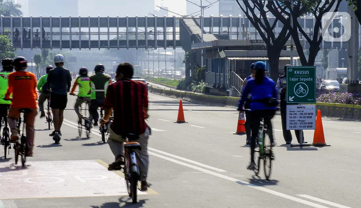 Warga berolahraga menggunakan sepeda di sepanjang Jalan Sudirman, Jakarta, Minggu (26/7/2020). Pemprov DKI menyiapkan 30 kawasan khusus pesepeda di lima kota administrasi Jakarta. (Liputan6.com/Faizal Fanani)