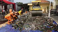 Petugas memusnahkan barang bukti miras dan narkoba di halaman Polsek Palmerah, Jakarta Barat, Senin (14/5). Pemusnahan dilakukan untuk menciptakan suasana kondusif menjelang bulan suci Ramadan. (Liputan6.com/Arya Manggala)